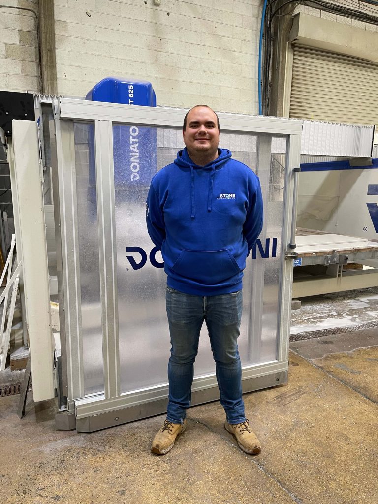 Matt Pickard wearing his Stone Automation uniform standing in front of a Donatoni Jet 625 for a photo